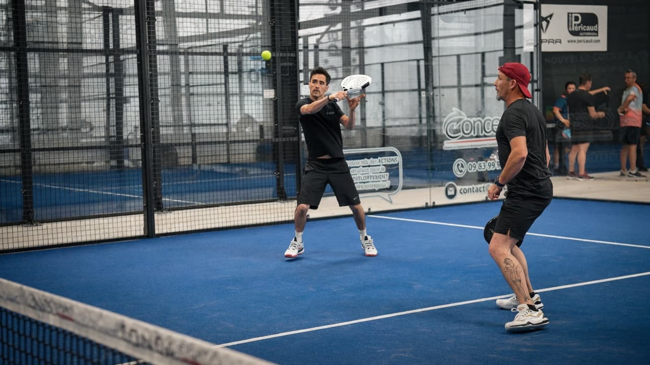Joueur de padel en action sur un court indoor O’Padel à Brive